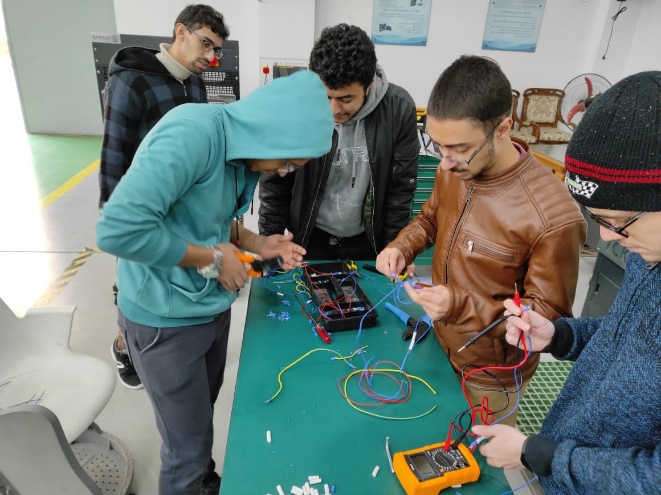 A group of men working on a machine Description automatically generated with low confidence
